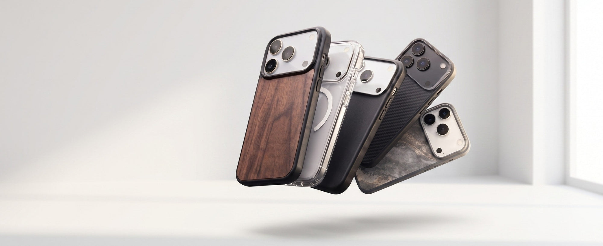 Plusieurs coques et étuis durables Woodcessories pour iPhone 18 Pro et iPhone 18 Pro Max flottent dans une pièce baignée par la lumière qui pénètre par une fenêtre située à droite.