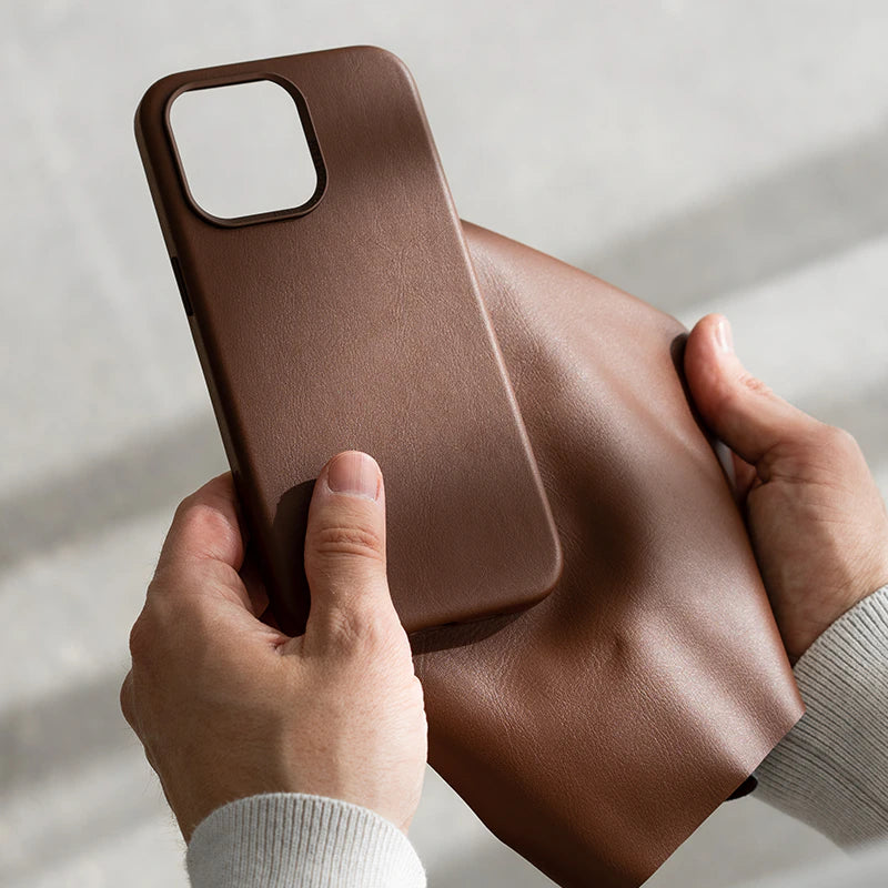 Person hält ein leeres, braunes iPhone 17  Leder-Case und ein Stück braunes Leder in den Händen.